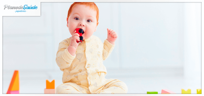 Bebê ruivo colocando um carrinho na boca - engasgo infantil