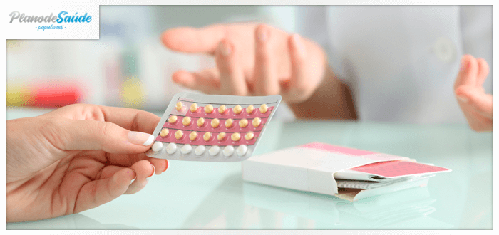 Mulher segurando cartela de anticoncepcional